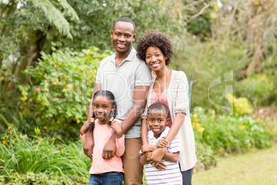 Happy family standing outside together