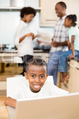 Son using laptop in the kitchen