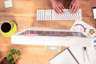 Cropped image of hands typing on computer keyboard