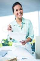 Smiling businesswoman sitting on her desk