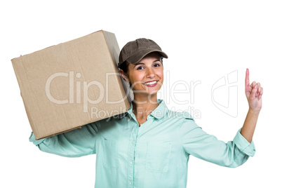 Smiling delivery woman holding box pointing up