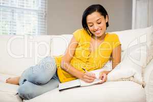 Smiling brunette writing on note pad