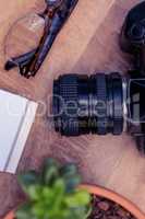Camera by eye glasses on wooden table