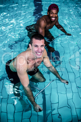 Fit men cycling in the pool