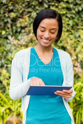 Smiling brunette using tablet