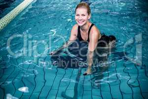 Smiling woman cycling in the swimming pool