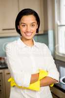 Smiling brunette with arms crossed wearing yellow gloves