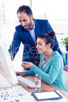 Young businessman and businesswoman working on computer