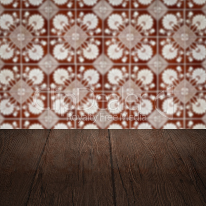 Wood table top and blur vintage ceramic tile pattern wall