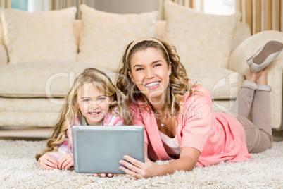 Happy mom and daughter lying on the floor