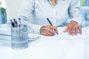 Businesswoman writing on white paper