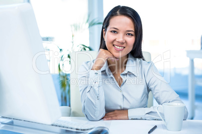 Smiling businesswoman with chin on fist