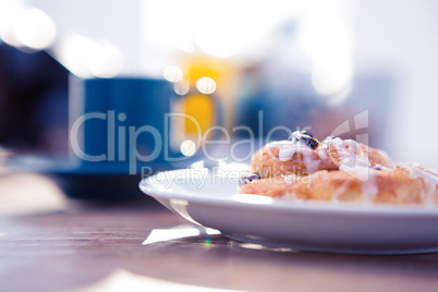 Sweet food served in plate by coffee cup