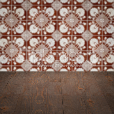 Wood table top and blur vintage ceramic tile pattern wall