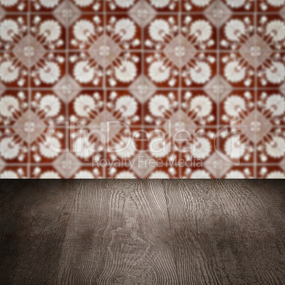 Wood table top and blur vintage ceramic tile pattern wall Wood table top and blur vintage ceramic tile pattern wall