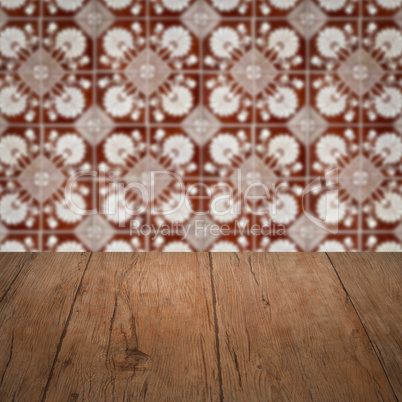 Wood table top and blur vintage ceramic tile pattern wall