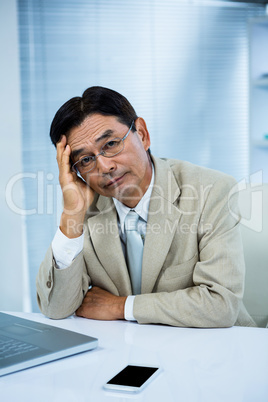 Undecided businessman looks his computer