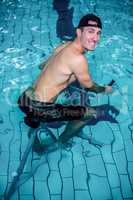 Fit man cycling in the pool