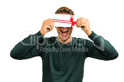 Cheerful man hiding face with gift