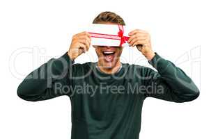 Cheerful man hiding face with gift