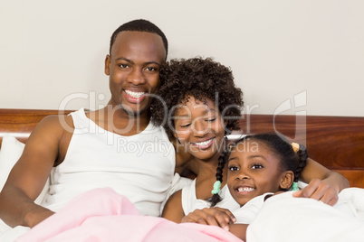 Happy family lying in bed together