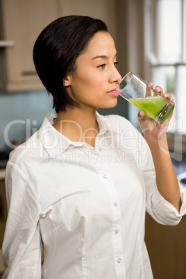 Smiling brunette drinking healthy smoothie