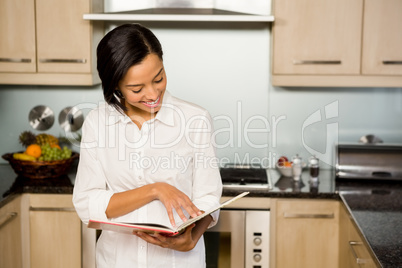 Smiling brunette reading book