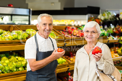 Senior customer and worker discussing vegetables