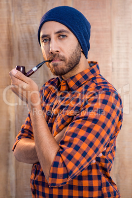 Portrait on confident businessman holding smoking pie against wa