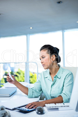 Smiling young businesswoman calculating bills