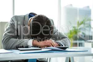 Businessman lying on his desk