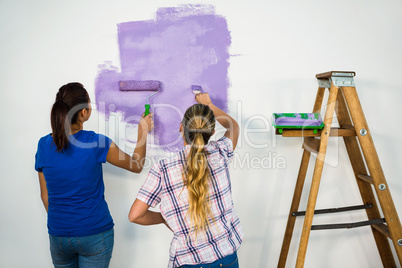 Friends painting a wall