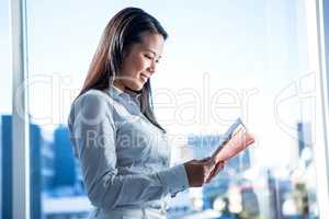 Smiling businesswoman reading book