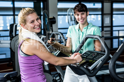 Fit woman doing exercise bike with trainer Fit woman doing exercise bike with trainer