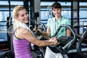 Fit woman doing exercise bike with trainer