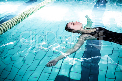 Relaxed woman floating in the swimming pool