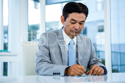 Businessman writing on paper