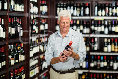 Smiling senior man choosing wine