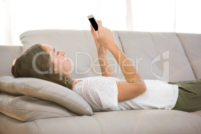 Woman holding phone on sofa
