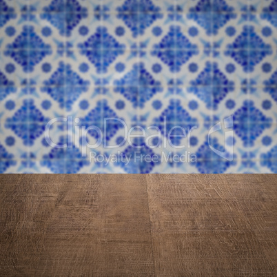 Wood table top and blur vintage ceramic tile pattern wall