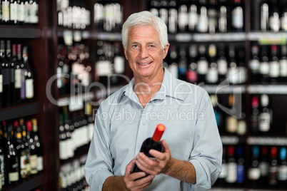 Smiling senior man choosing wine