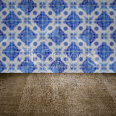 Wood table top and blur vintage ceramic tile pattern wall