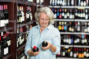 Smiling senior woman choosing wine