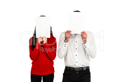 Couple covering their faces with documents
