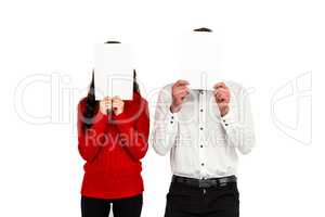 Couple covering their faces with documents