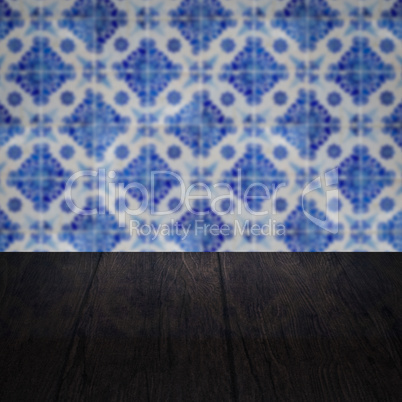 Wood table top and blur vintage ceramic tile pattern wall