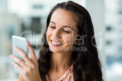 Smiling woman using smartphone