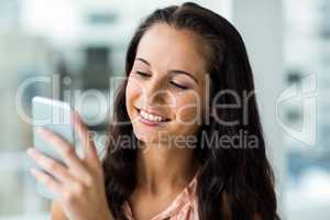 Smiling woman using smartphone