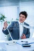 Angry asian businessman shouting on the phone