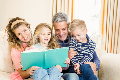 Happy parents reading to their kids